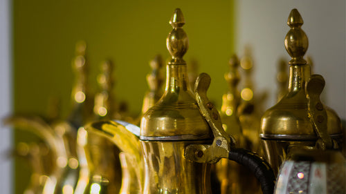 A shelf of traditional Arabic dallah coffee brewers.