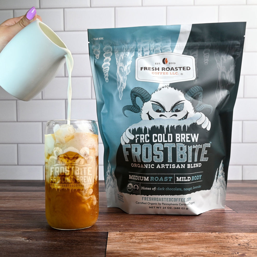 Fresh Roasted Coffee Frostbite Cold Brew over ice, milk being poured for a smooth, chocolaty medium roast flavor.